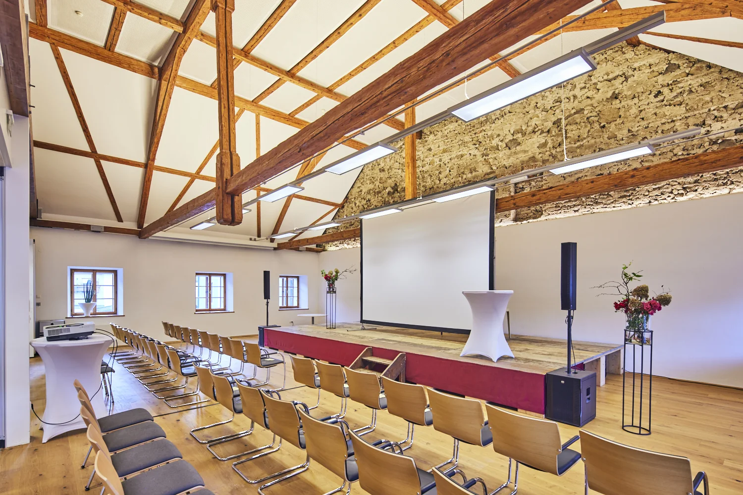 Saal mit Bühne, Leinwand und Bestuhlung